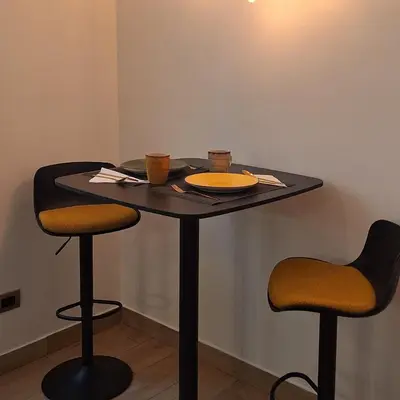 a table with two stools with a plate and two cups at Domus Albalonga in Rome