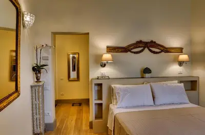 a bedroom with a bed with white pillows and a mirror at Casa Sotgiu Guest House in Rome