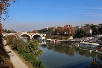 a river with a bridge and boats in a city at Casa Sotgiu Guest House in Rome