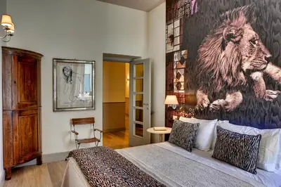 a bedroom with a large painting of a lion on the wall at Casa Sotgiu Guest House in Rome
