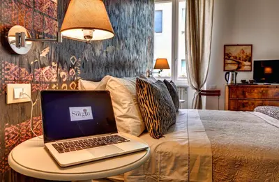 a laptop computer sitting on a table on a bed at Casa Sotgiu Guest House in Rome