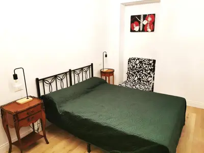 a bedroom with a green bed and a chair at Casa D'Agata in Rome
