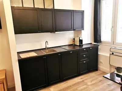 a kitchen with black cabinets and a sink at Casa D'Agata in Rome