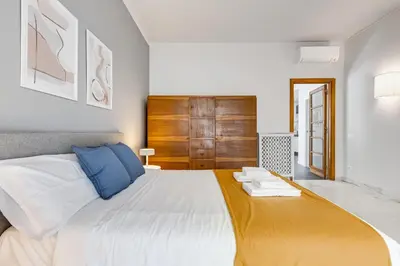 a bedroom with a large white bed and a wooden door at FaMa - Quiet&Bright 2BR Apartment in Rome