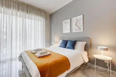 a bedroom with a large bed and a large window at FaMa - Quiet&Bright 2BR Apartment in Rome