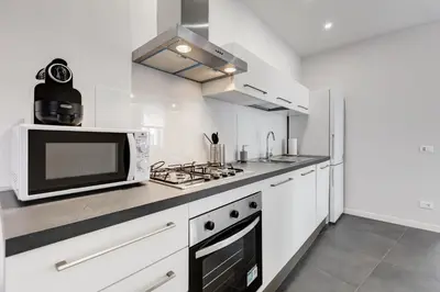 a white kitchen with a microwave and a stove at FaMa - Quiet&Bright 2BR Apartment in Rome