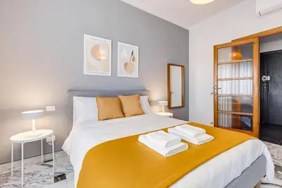 a bedroom with a large bed with a yellow blanket at FaMa - Quiet&Bright 2BR Apartment in Rome