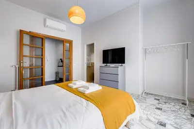 a white bedroom with a bed and a television at FaMa - Quiet&Bright 2BR Apartment in Rome