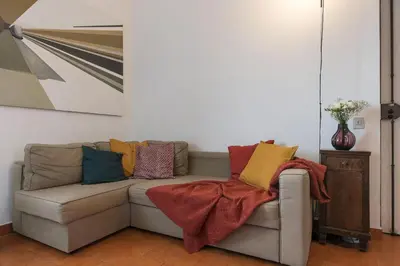 a living room with a couch with colorful pillows at Casa di Cosimo - WelcomeToRhome in Rome