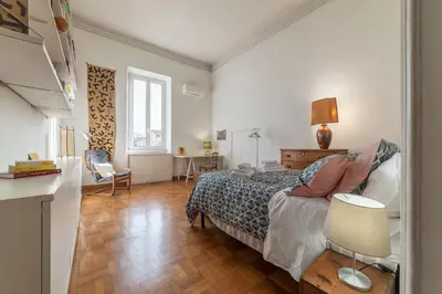 a bedroom with a bed and a table and a chair at Casa di Cosimo - WelcomeToRhome in Rome