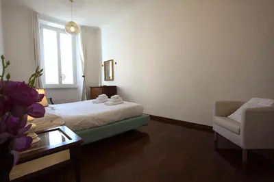 a bedroom with a bed and a chair and a table at La Finestra sulla Basilica in Rome
