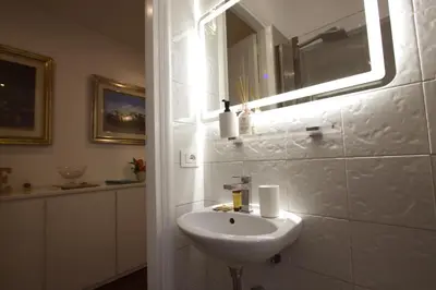a white bathroom with a sink and a mirror at La Finestra sulla Basilica in Rome