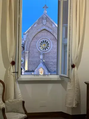 a window view of a church with a clock tower at La Finestra sulla Basilica in Rome