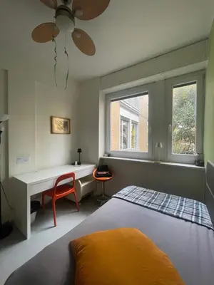 a bedroom with a bed and a desk and a window at Olimpic Sunny room in Rome