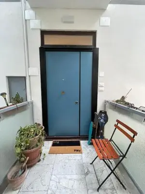 a bench and a blue door in a building at Olimpic Sunny room in Rome