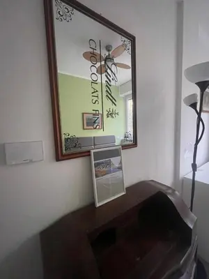 a mirror on a wall above a wooden table at Olimpic Sunny room in Rome