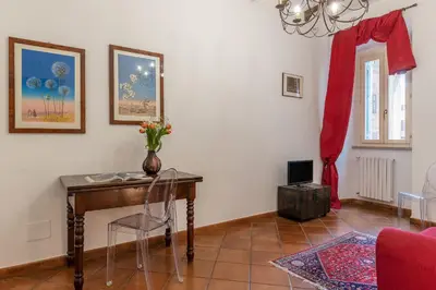 a room with a table with a vase of flowers on it at Casa Fiori - WelcomeToRhome in Rome