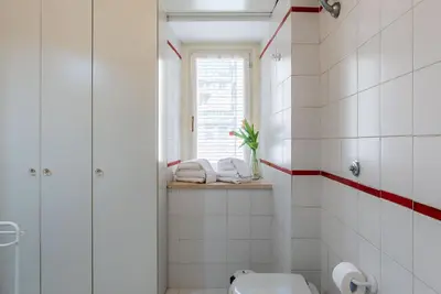 a white bathroom with a toilet and a window at Casa Fiori - WelcomeToRhome in Rome