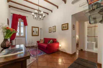 a living room with a red couch and a table at Casa Fiori - WelcomeToRhome in Rome