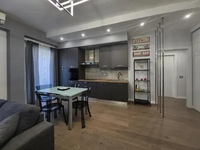 a living room with a table and a kitchen at Patrica house in Rome