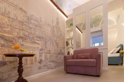 a living room with a chair and a drawing on the wall at NOH Forum Patio in Rome