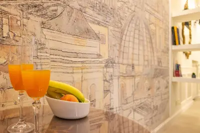 a bowl of fruit and a glass of orange juice at NOH Forum Patio in Rome