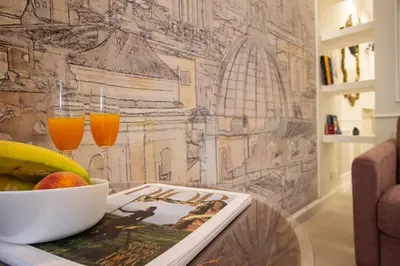 a table with a bowl of fruit and two glasses of orange juice at NOH Forum Patio in Rome