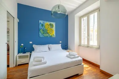 a blue bedroom with a white bed and a blue wall at Nostromondo BIANCAMANO ATTIC - Stylish penthouse with private terrace- San Giovanni in Rome