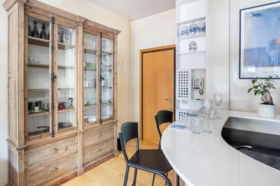 a kitchen with a large white counter and chairs at Boutique Caravaggio in Rome