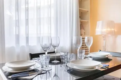 a dining room table with plates and wine glasses at Boutique Caravaggio in Rome