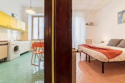 a room with a bed and a kitchen with a table at Casa di Vigo - WelcomeToRhome in Rome