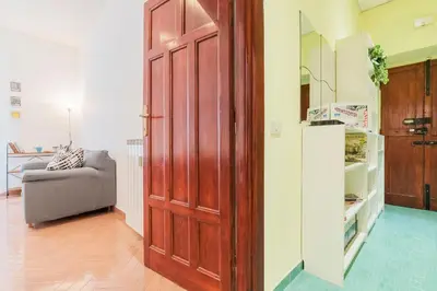 a large wooden door in a living room with a couch at Casa di Vigo - WelcomeToRhome in Rome