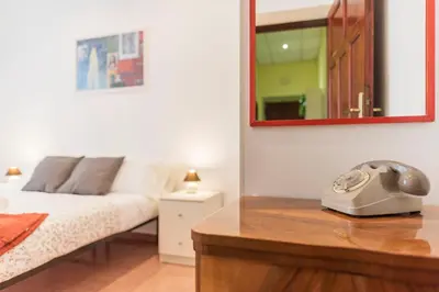 a bedroom with a bed and a mirror on a desk at Casa di Vigo - WelcomeToRhome in Rome