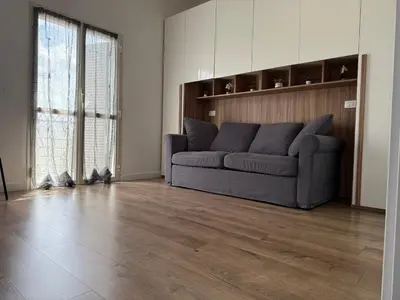a living room with a couch and a wooden floor at Sunflower House in Rome