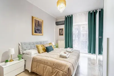 a bedroom with a large bed with green curtains at 7th Floor Terrace Stay - San Giovanni & Colosseum in Rome