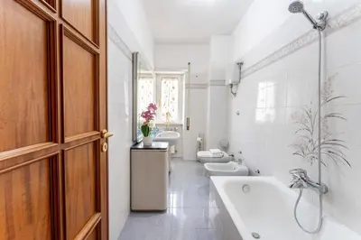 a white bathroom with two sinks and two toilets at 7th Floor Terrace Stay - San Giovanni & Colosseum in Rome