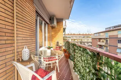a balcony with a table and chairs on a building at 7th Floor Terrace Stay - San Giovanni & Colosseum in Rome