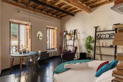 a bedroom with a bed and a table and chairs at GuestHost - Vintage-Modern Apartment Trastevere in Rome