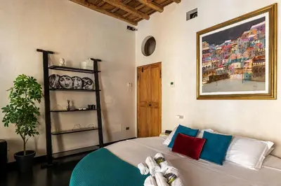 a bedroom with a bed and a painting on the wall at GuestHost - Vintage-Modern Apartment Trastevere in Rome