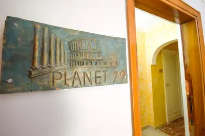a sign on the wall of a building with the coliseum at Guest House Planet 29 in Rome