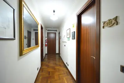 a corridor of a hallway with a door and a mirror at Guest House Planet 29 in Rome