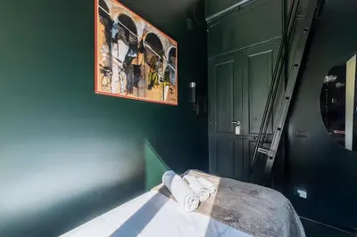 a green room with a bed with towels on it at GuestHost - San Pietro Studio Apartment Roma in Rome