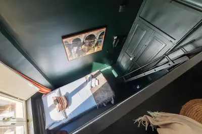 a green room with a bed and towels on a wall at GuestHost - San Pietro Studio Apartment Roma in Rome
