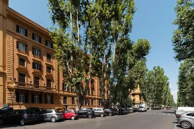 a street with cars parked in front of a building at GuestHost - San Pietro Studio Apartment Roma in Rome