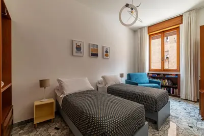 a bedroom with a bed and a blue chair at Casa Luisa - WelcomeToRhome in Rome