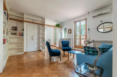 a living room with a blue couch and chairs at Terrazza di Flamy - WelcomeToRhome in Rome