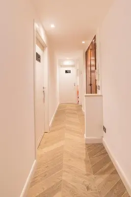 an empty hallway with white walls and wood floors at Victoria Rooms in Rome