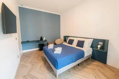 a bedroom with a blue and white bed with towels on it at Victoria Rooms in Rome