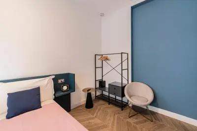 a bedroom with a bed and a chair at Victoria Rooms in Rome