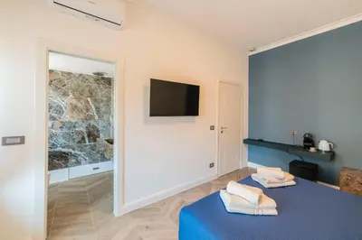 a room with a bed and a tv on the wall at Victoria Rooms in Rome